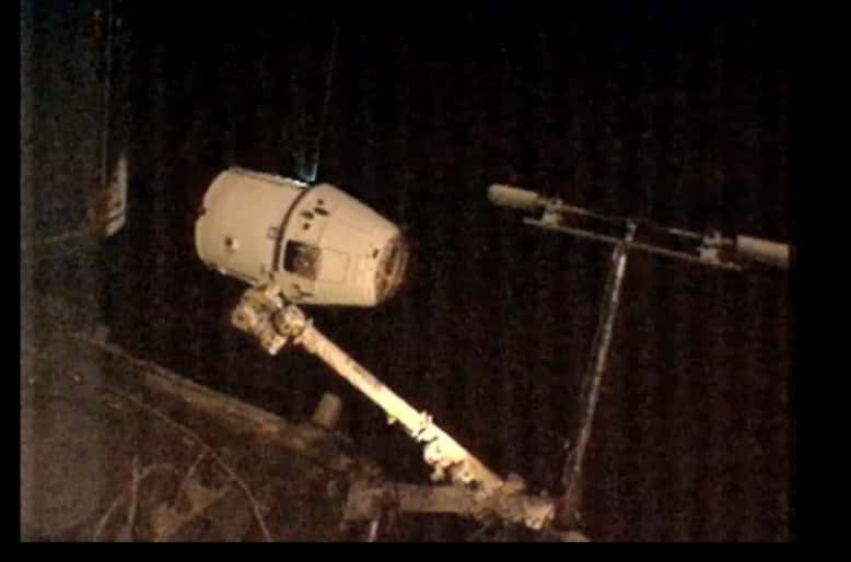 Le bras Canadarm2, commandé par deux astronautes installés dans la coupole, s'approche de la capsule Dragon pour l'accrocher. © Nasa TV