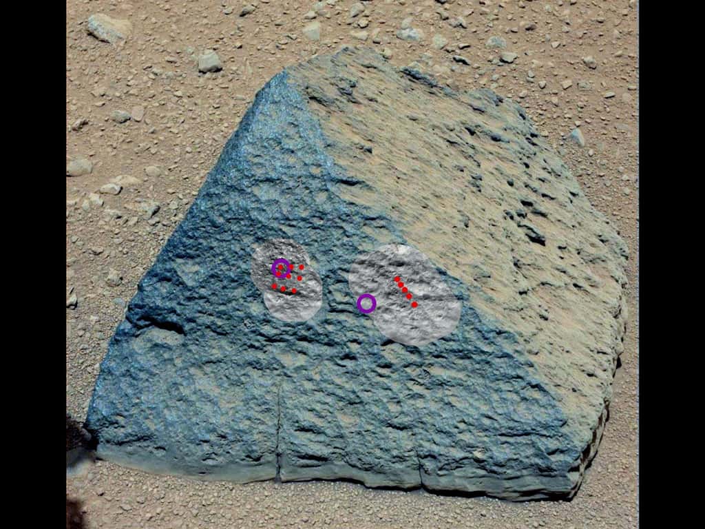 Sur cette image de la roche baptisée « Jake Matijevic », les points rouges représentent les points d'impact du laser de la ChemCam et les zones claires (en noir et blanc) montrent les régions qu'elle a observées. Les cercles violets sont les zones étudiées avec l’<em>Alpha Particle X-Ray Spectrometer</em> (APXS). © Nasa/JPL-Caltech/MSSS