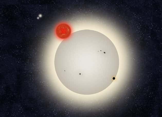 Une vue d'artiste du transit de PH1 (le cercle noir en bas à gauche) devant la plus grosse des deux étoiles (représentée comme une étoile ressemblant au Soleil) autour desquelles tourne cette exoplanète. C'est ce transit, trahi par une très légère baisse de luminosité, qu'ont repéré les astronomes amateurs du programme <em>Planet hunters</em> en analysant les données du télescope spatial Kepler. Le compagnon de la grande étoile est représenté comme une naine rouge. Plus loin, deux étoiles tournent elles aussi, comme des planètes... © Haven Giguere/Yale