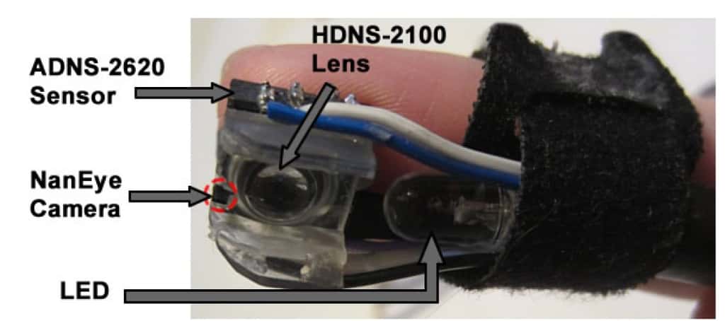 Fixé sur le bout des doigts à l'aide d'un anneau réglable en Velcro, le prototype de Magic Finger permet de piloter un ordinateur, une tablette ou un smartphone à partir de n’importe quelle surface. Le dispositif est doté d’un capteur optique équivalent à celui des souris (HDNS-2100), une microcaméra (NanEye Camera) et une Led. Un autre capteur optique (ADSN-2620) est également disponible pour détecter les textures, mais elle reste moins performante que la microcaméra. © Autodesk Research