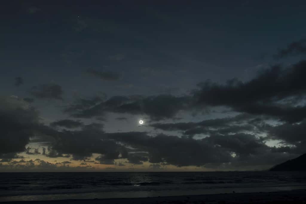 Miracle sur la côte australienne. Les nuages s'écartent pendant les deux minutes que dure la phase totale de l'éclipse solaire. La brillante planète Vénus est également visible plus haut dans le ciel. © Efremidis Yiannis