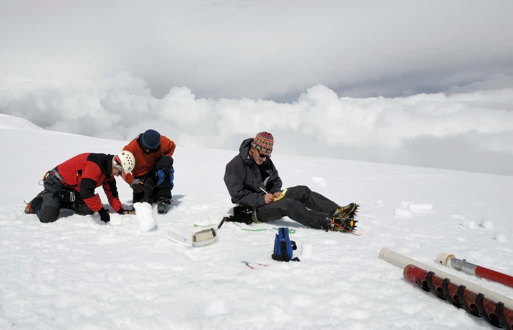 Mesures en zone d'accumulation. À 5.400 m, sur le glacier Antizana, en Équateur, le glaciologue Bernard Francou évalue la densité de la glace et de la neige du carottage. © Bernard Francou