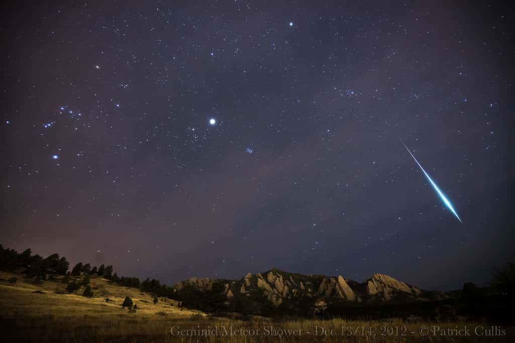 Une brillante Géminide (on peut comparer son éclat à celui de Jupiter, au centre de l'image) survole les Flatirons, des formations rocheuses dans le Colorado. © Patrick Cullis