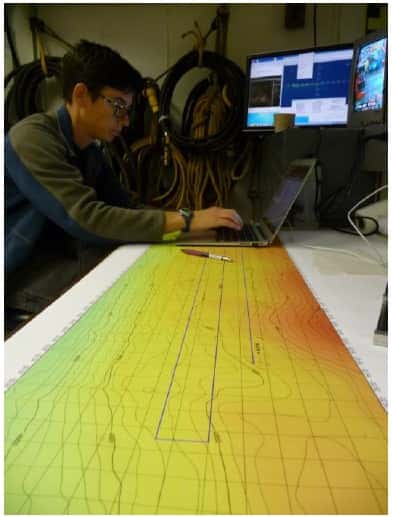 Les scientifiques à bord du <em>JOIDES Resolution</em> travaillent sur les cartes bathymétriques du rift du Hess Deep, pour déterminer le prochain lieu de forage. © Jean-Luc Berenguer