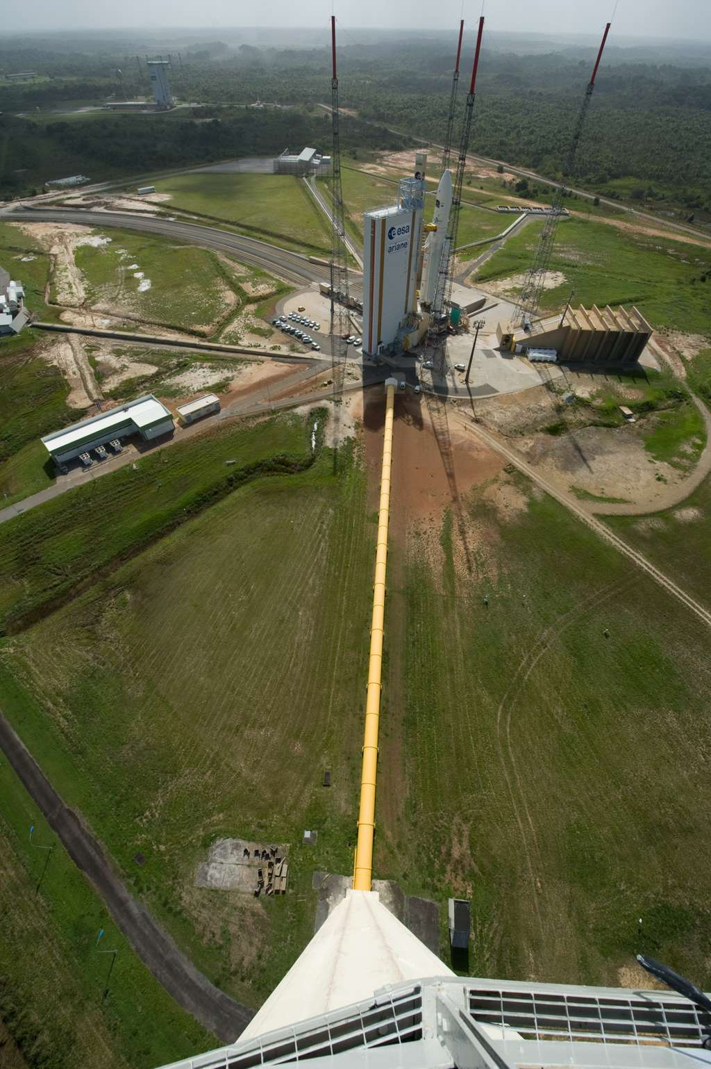 En plus des pas de tir de Vega (en haut et à gauche), d'Ariane 5 (au premier plan) et du Soyouz russe, le Centre spatial guyanais va devoir en construire un pour Ariane 6. La photo est prise depuis le réservoir d'où sera déversée de l'eau (dans la canalisation jaune), au moment du lancement, pour atténuer les vibrations sonores au moment du décollage. © Esa, S. Corvaja