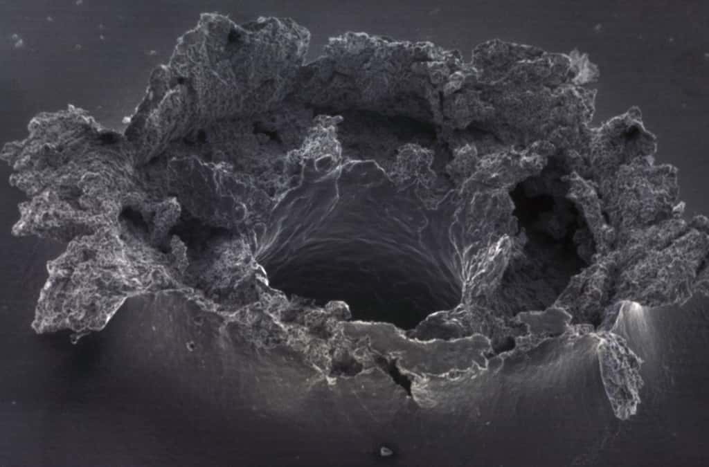 Gros plan sur un impact de débris spatial examiné au microscope électronique à balayage. © Cnes, 1998