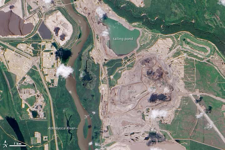 Le Canada est le premier producteur de pétrole à partir de sable bitumineux. Ici, en photo, l'exploitation minière de sable bitumineux de l'Athabasca (Alberta, Canada). L'image montre la rivière Athabasca à environ 600 m de l'étang de résidus miniers. © <em>Nasa Earth Observatory</em>, DP