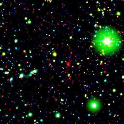 Spitzer observant un amas galactique, situé à 9.09 milliards d'années-lumière de la Terre. <br />Dans cette image composite en fausses couleurs, les galaxies faisant partie de l'amas sont visibles sous la forme de points rouges. <br />Les tâches vertes sont, quant à elles, des étoiles de la Voie Lactée, et les points bleus des galaxies pâles <br />(Crédits : NASA/JPL-Caltech/UCDavis/Lawrence Livermore National Laboratory) 