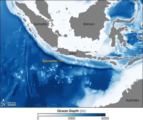 Vue par satellite de la zone du tsunami qui a touché l'île de Java le 17 juillet 2006<br />Y figurent notamment la profondeur de l'océan (la couleur bleu foncé correspond aux grandes profondeurs) et le lieu de l'épicentre du séisme, à 250 kilomètres des côtes. <br />Celui-ci se trouvait sur une zone où l'océan gagne brutalement en profondeur <br />(Crédits : Jesse Allen, Earth Observatory.)