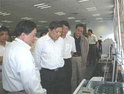 LI Guojie, directeur de l'Institut de technologie informatique montre le nouveau processeur<br />au ministre de la Recherche et de la Technologie