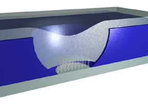 Dans une couche de silicium (en bleu), les scientifique ont creusé un pore obturé des deux côtés par des électrodes en cobalt et en nickel (en gris). Dans le minuscule espace d'environ 40 nanomètres ménagé entre les deux, des composés organiques s'organisent d'eux-mêmes en une couche mono-moléculaire (petits ressorts blancs sur l'image). Par effet tunnel, le courant les traverse et on peut ainsi contrôler l'aimantation des électrons, ou spin. Crédit : W. Wang, C.A. Richter / NIST