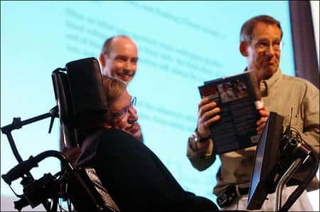A gauche, Stephen Hawking et à droite John Preskill. En 2004, Hawking concéda qu'il avait perdu son pari sur la destruction de l'information par un trou noir. Preskill, qui avait soutenu la conservation de l'information et en avait fait le pari avec Hawking, tient son prix, une encyclopédie du baseball. Crédit : <em>Caltech University</em>