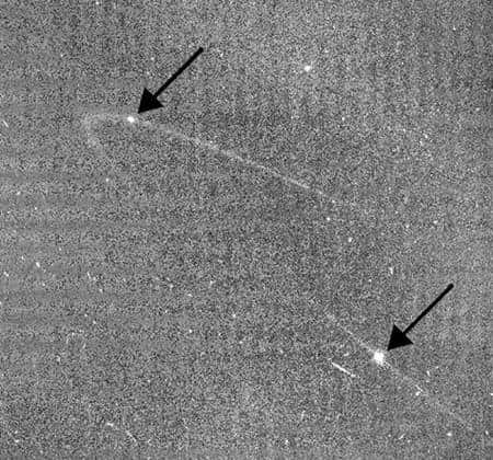 Les flèches indiquent les positions d’Anthe (en haut à gauche) et de Methone (en bas à droite). Les impacts de micrométéorites sont la source probable de ces arcs. Crédit : Nasa/JPL/<em>Space Science Institute</em>