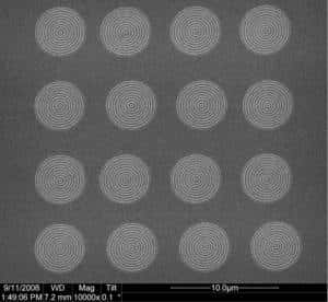 Seize lentilles constituées de simples cercles concentriques gravés sur une plaque d'argent. Sous l'effet d'un rayonnement ultraviolet, elles émettent des ondes de longueurs d'onde plus courtes au niveau du trou central. (Cliquez pour agrandir.) © Xiang Zhang Lab/UC Berkeley