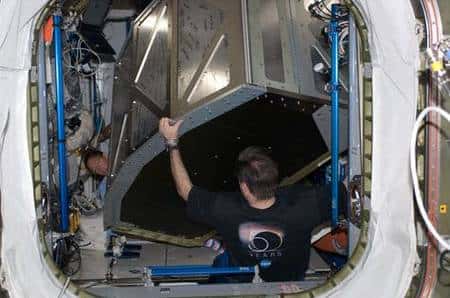 Greg Chamitoff, spécialiste de mission, déplace une cabine de repos que vient de livrer l'équipage d'Endeavour vers le module Harmony. Remarquez les nombreuses signatures sur la paroi du caisson. Cliquer pour agrandir. Crédit Nasa