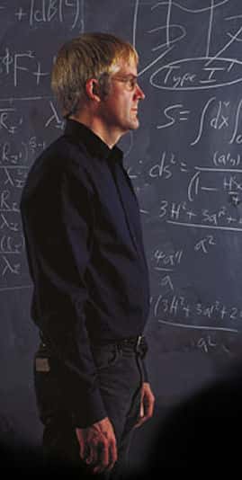 Joseph Lykken, un théoricien des cordes spécialisé dans la phénoménologie des particules élémentaires devant des calculs de cosmologie relativiste et de théorie des cordes. Crédit : <em>Quantum Universe</em>