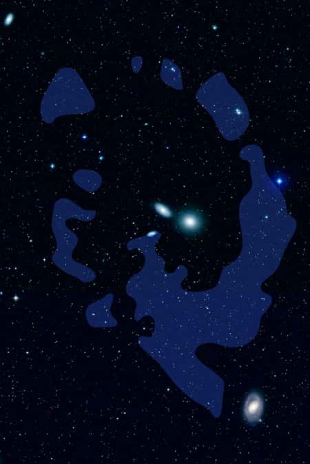 En bleu, les nuages d'hydrogène neutre de l'Anneau du Lion orbitant autour d'un groupe de galaxies dans la constellation du Lion, comme l'elliptique NGC 3384 (au centre de l'anneau), située à 35 millions d'années-lumière environ. Le diamètre de l'anneau est évalué à 200 kilo-parsecs. Crédit : Nasa/JPL-Caltech/DSS
