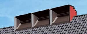 Trois modules de l'éolienne de toiture AéroCube installés sur le faîtage d’une maison. Les pales sont invisibles. © DR