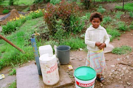 Cette fillette d’Afrique du Sud profite d’un robinet installé dans sa communauté. Auparavant, les habitants devaient aller chercher l’eau plusieurs fois par jour dans une rivière polluée. © Lionel Goujon et Gwenael Prié