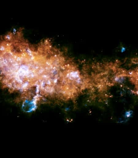 Cliquer pour agrandir. Cette image est prise en regardant une région de la Galaxie dans la constellation de l'Aigle, près du centre galactique. Au centre et à gauche de l'image, les deux régions de formation stellaire G29.9 et W43 sont clairement visibles. Des centaines d'étoiles de toutes tailles, allant de celles similaires à notre Soleil à des monstres de plusieurs dizaines de fois plus lourds y naissent en ce moment même. Les flux de rayonnement des nouvelles étoiles détruisent les restes des nuages de gaz d'origine et creusent des cavités géantes dans la Galaxie. Crédits : Esa/<em>Hi-GAL Consortium</em>