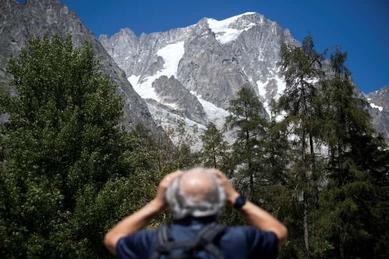 Un homme observe avec des jumelles le glacier de Planpincieux à Courmayeur, le 6 août 2020 au Val Ferret, en Italie. © Marco Bertorello, AFP 