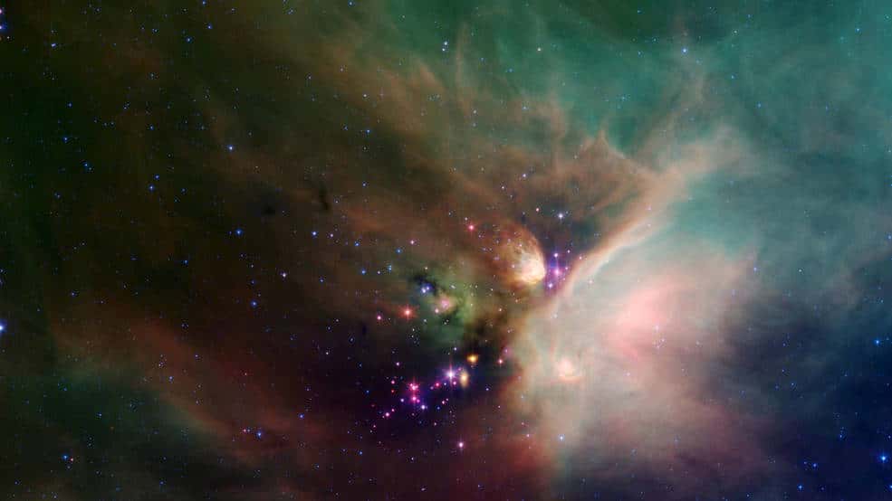 Des étoiles jettent un coup d'œil sous leur couverture natale de poussière dans cette image dynamique du nuage sombre <em>Rho Ophiuchi</em> du télescope spatial Spitzer. Appelée « Rho Oph » par les astronomes, c'est l'une des régions de formation d'étoiles les plus proches de notre système solaire, à environ 407 années-lumière de la Terre. © Nasa, JPL-Caltech