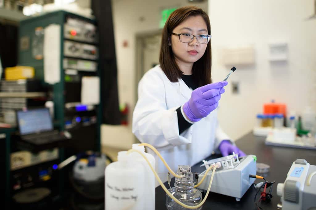 La chimiste Chong Liu examinant une électrode en carbone couverte d'amidoxime dans le cadre d'une recherche visant à améliorer l'extraction de l'uranium de l'eau de mer. © L. A. Cicero