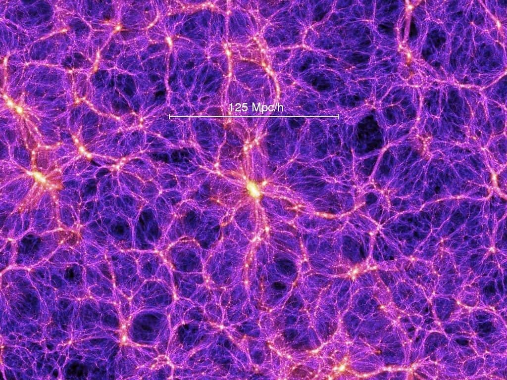 Sur cette image provenant d'une des meilleures simulations de la formation des grandes structures de l'univers, des filaments de matière noire contenant des superamas de galaxies apparaissent clairement. On note aussi la présence de grands vides que l'on appelle parfois des vides cosmiques (<em>cosmic voids</em> en anglais) La barre blanche indique l'échelle des distances en mégaparsecs corrigée par le facteur h lié à la constante de Hubble. On estime que h est compris entre 0,65 et 0,70, la meilleure estimation en 2014 étant de 0,68. © <em>Max Planck Institute for Astrophysics</em>, <em>Millennium Simulation Project</em>