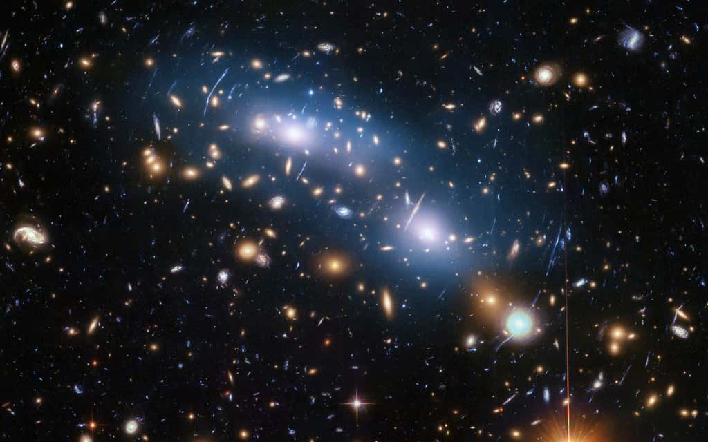 Cette image du télescope spatial Hubble de la Nasa/ESA montre l'amas de galaxies MACS J0416. Il s'agit de l'un des six amas étudiés par le programme <em>Hubble Frontier Fields</em>, qui a produit les images les plus profondes de lentilles gravitationnelles jamais réalisées. Les scientifiques ont utilisé la lumière intra-amas (visible en bleu) pour étudier la distribution de la matière noire au sein de l'amas. © Nasa, ESA et M. Montes (Université de New South Wales, Sydney, Australie)  
