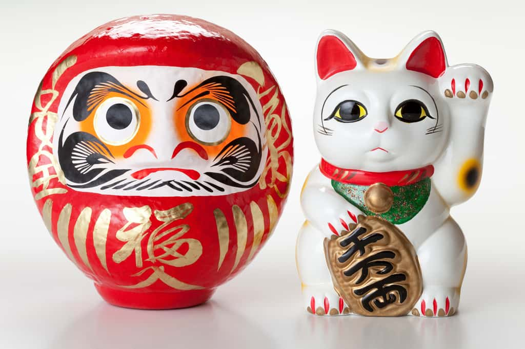 Le Daruma et le Maneki-neko, deux figurines incontournables de la décoration japonaise. © Paylessimages, Adobe Stock