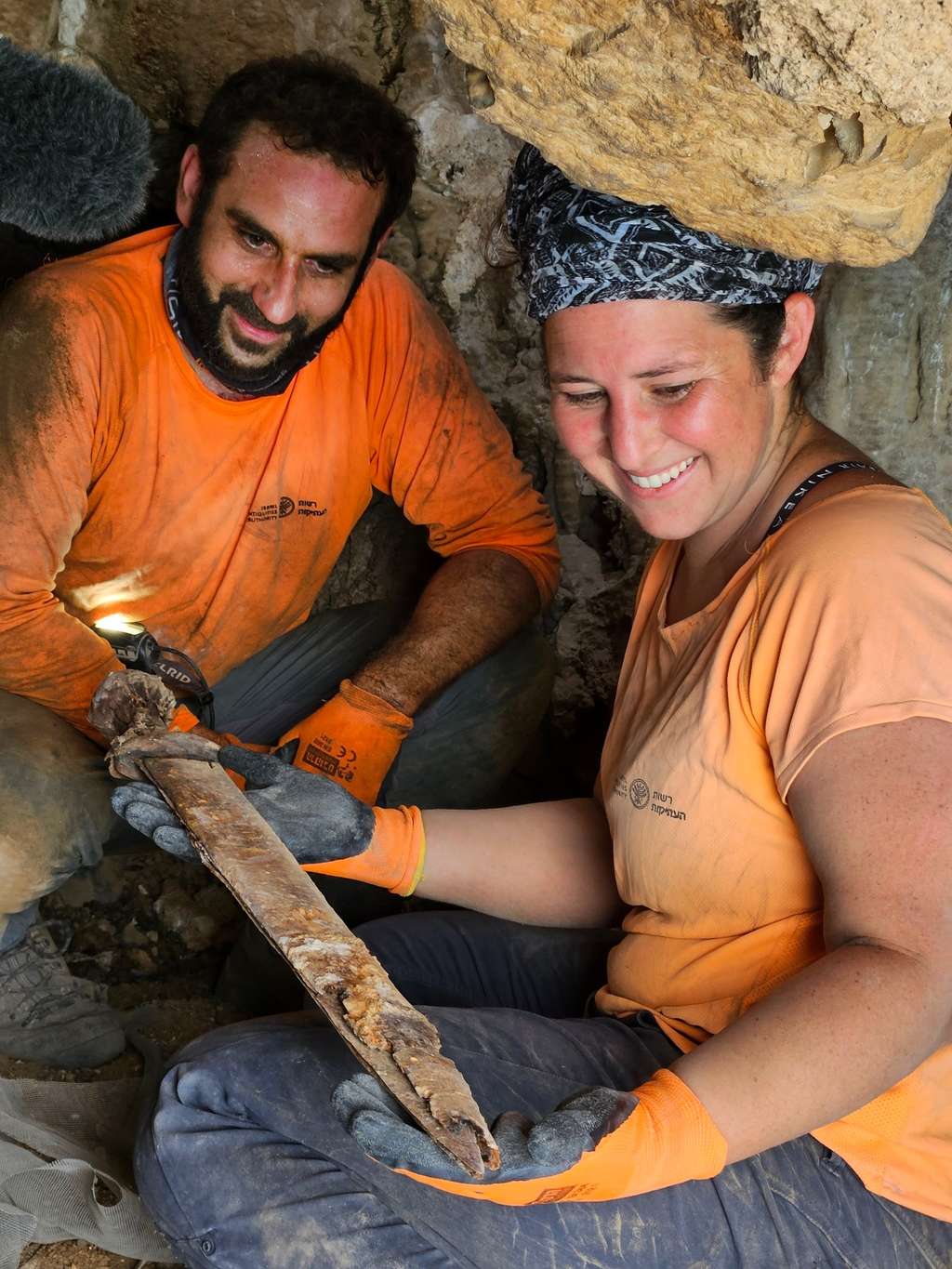 Les archéologues avec l'une des armes. © Amir Ganor, <em>Israel Antiquities Authority</em> 