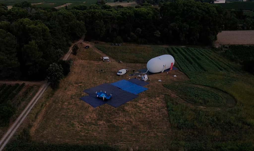 Cette photo montre le ballon régulateur gonflé et l’équipe du projet qui est en train de positionner le ballon porteur. La chaîne de vol totale fait 70 mètres de haut. © Zephalto