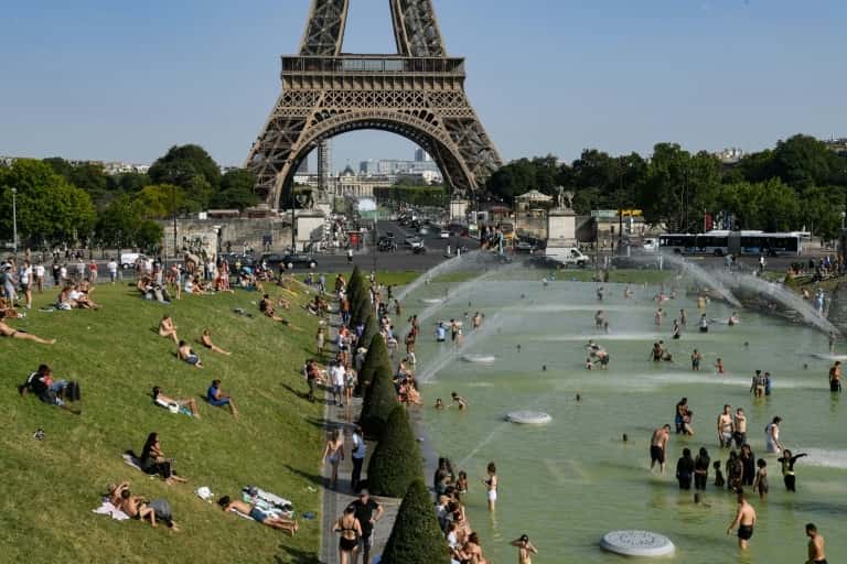 Les Parisiens se rafraîchissent dans les fontaines du Trocadéro, près de la Tour Eiffel, le 23 juillet 2019 à Paris. © Bertrand Guay, AFP