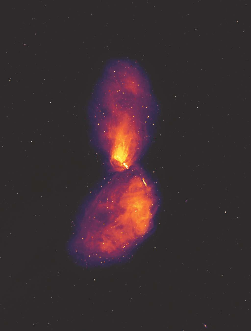  Cette image montre la galaxie Centaurus A à des longueurs d'onde radio, révélant de vastes lobes de plasma qui s'étendent bien au-delà de la galaxie visible, qui n'occupe qu'une petite zone au centre de l'image. Les points à l'arrière-plan ne sont pas des étoiles, mais des radiogalaxies un peu comme Centaurus A, à des distances bien plus grandes. © Ben McKinley, ICRAR/Curtin and Connor Matherne, Louisiana State University