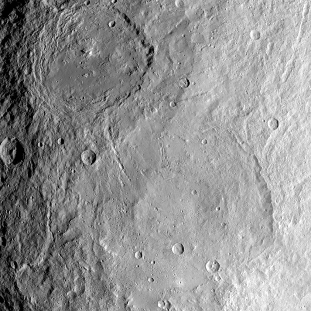 Cette image prise par la sonde spatiale Dawn de la NASA montre les grands cratères Urvara (en haut) et Yalode (en bas) sur la planète naine Cérès. Les deux cratères géants se sont formés à des époques différentes. Urvara a environ 120 à 140 millions d'années et Yalode a presque un milliard d'années. © NASA/JPL-Caltech/UCLA/MPS/DLR/IDA