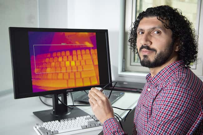 Le docteur Khamis montre l’image thermique d’un clavier sur lequel les doigts ont laissé des traces de chaleur. © Université de Glasgow