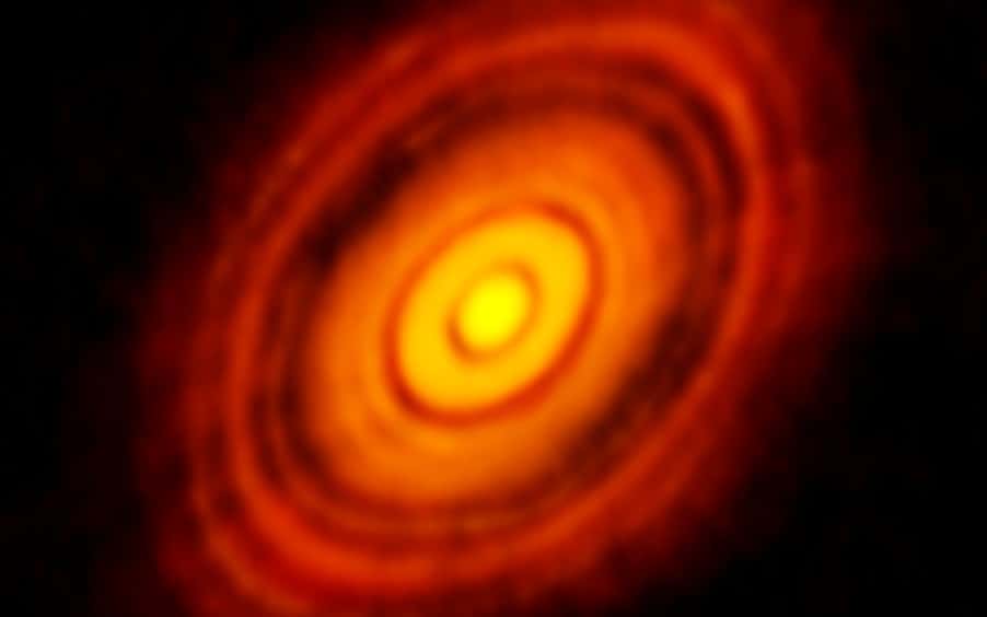 L’image la plus précise jamais réalisée avec Alma – plus précise que les images habituellement obtenues dans le visible avec le télescope spatial Nasa-Esa Hubble. Elle montre le disque protoplanétaire qui entoure la jeune étoile HL Tauri. Ces nouvelles observations d’Alma révèlent des structures dans le disque jamais observées auparavant et dévoilent même les emplacements possibles de planètes en formation dans les zones sombres au cœur du système. © Alma (ESO, NAOJ, NRAO)