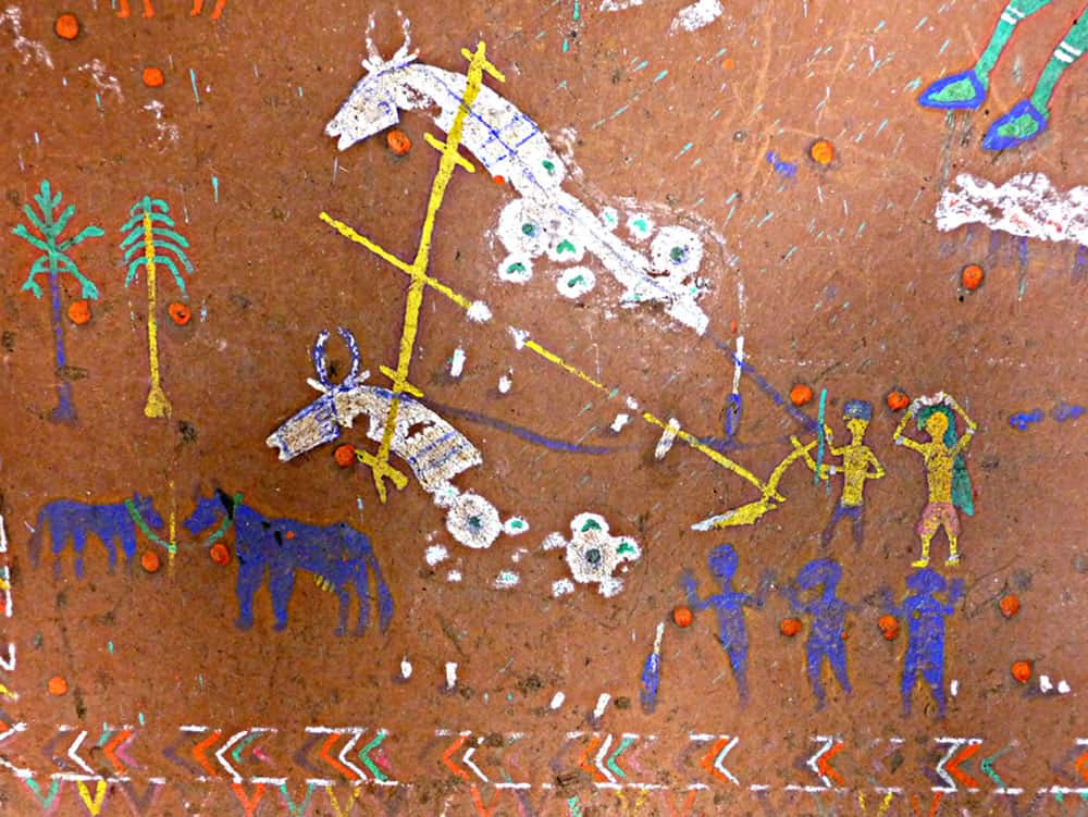 Détail d’une <em>pithera</em> (dessin mural dans une maison privée, village de Badhadeka, région de Jabhua, État du Madhya Pradesh) comportant des motifs traditionnels de l’art rupestre, tels que labours et danses. Les points rouges ont été apposés de manière propitiatoire (pour rendre la divinité propice), comme dans les abris, au cours de sa réalisation. © Jean Clottes, Meenakshi Dubey-Pathak