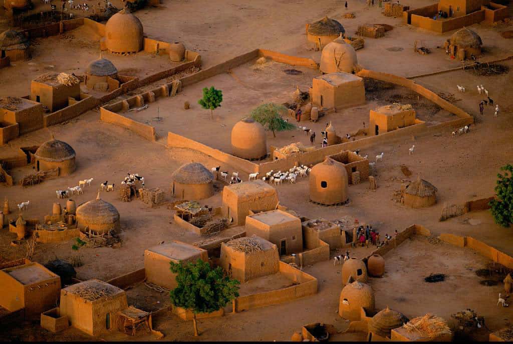 Détail d’un village aux environs de Tahoua, Niger (14°50’ N – 5°16’ E). Ce village près de Tahoua, dans le sud-ouest du Niger, présente une architecture haoussa caractéristique, avec ses maisons cubiques en banco (mélange de terre et de fibres végétales) associées à d’imposants greniers à grain aux formes ovoïdes. Majoritaire dans le pays (54 % de la population), le peuple haoussa est essentiellement constitué d’agriculteurs sédentaires. © Yann Arthus-Bertrand - Tous droits réservés