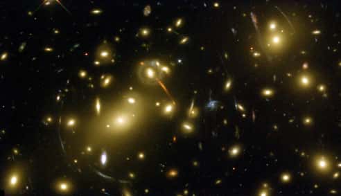 Image HST de l'amas de galaxies A2218. Chaque petite structure linéaire ou circulaire est « l'image » de galaxies très éloignées de l'amas, déformées et amplifiées par la masse de la matière que contient cet amas. ©<em> Space Telescope</em>