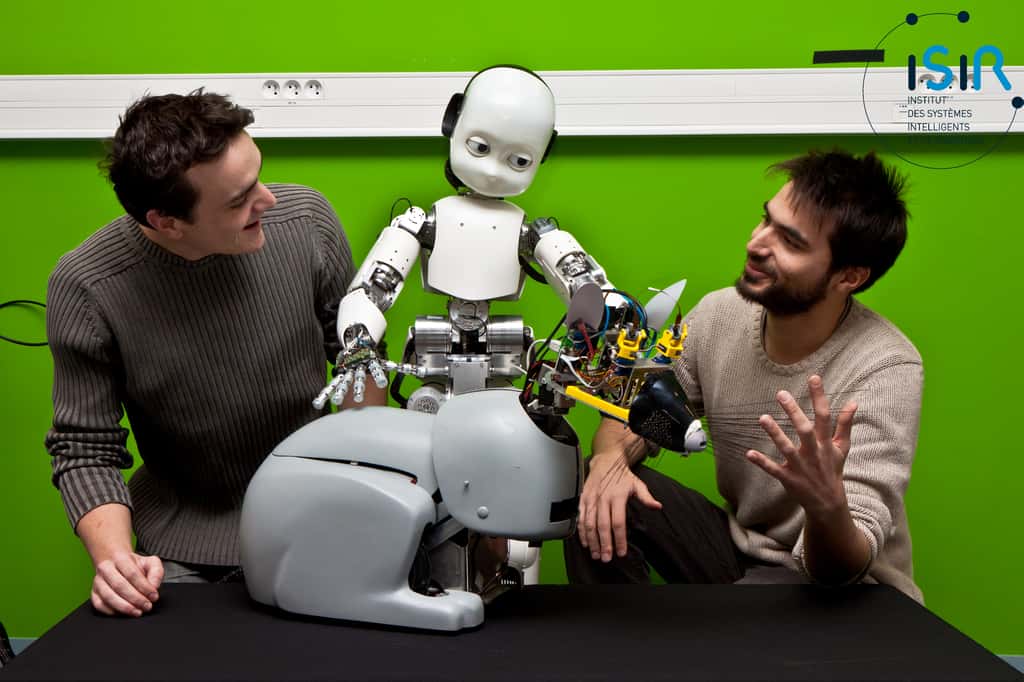 Camille Salaün, iCub et Mehdi Khamassi entourent le robot-rat Psikharpax. © Nicolas Fauverte (DR)/ISIR/Fauverte Nicolas