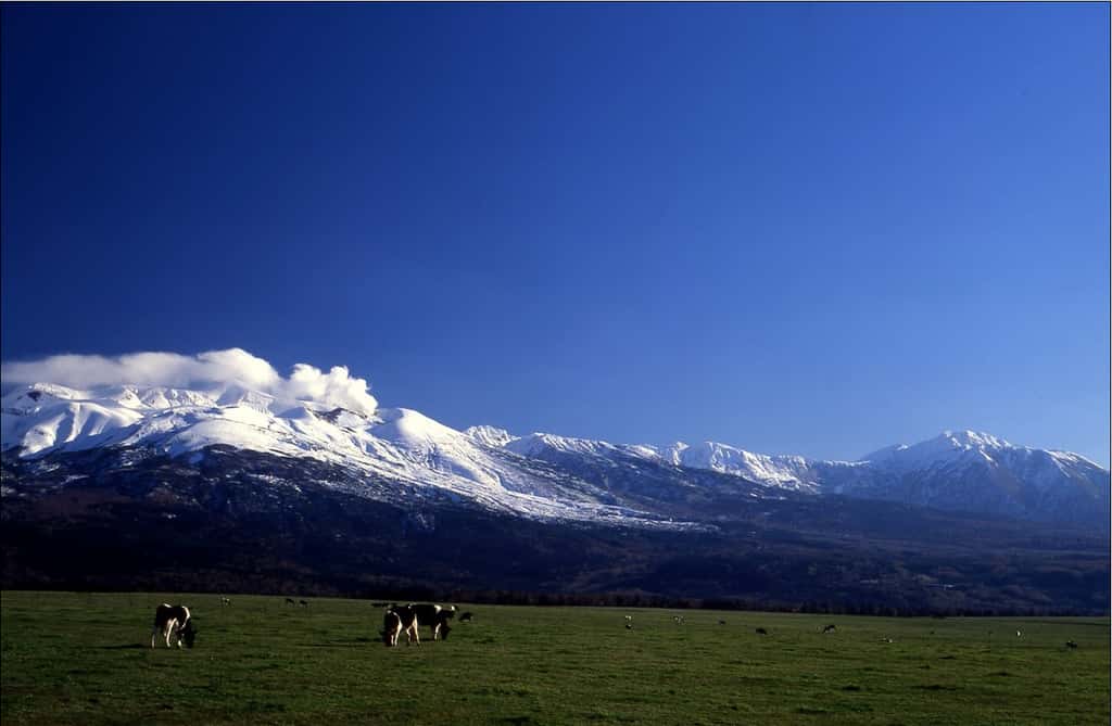 Les vastes étendues de plaine contrastent avec les montagnes enneigées dans les reliefs de l’île de Hokkaidō. Un somptueux panorama. © JNTO