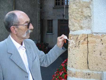 À Rochechouart, Claude Marchat présente les roches d'impact, sur les façades des maisons. © C. Frankel - Tous droits réservés