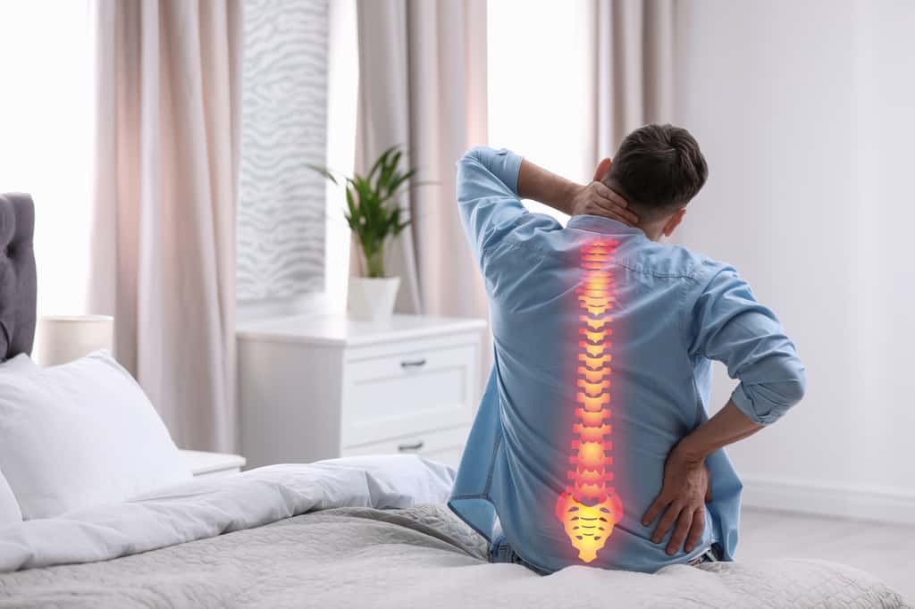 Une douleur soudaine dans le dos fait partie des symptômes de la myélite transverse. © New Africa, Adobe Stock