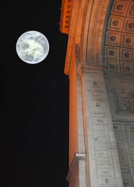 La Lune se couche en passant juste au-dessus de l'Arc de Triomphe