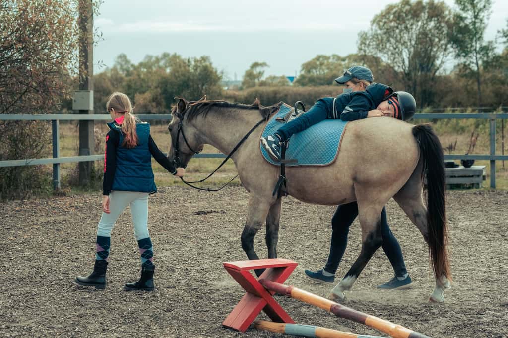 Grâce à une utilisation thérapeutique du cheval, l'équithérapeute met en place des exercices pour améliorer la motricité, le comportement ou encore l'estime de soi de ses patients. © Air_Lady, Adobe Stock. 