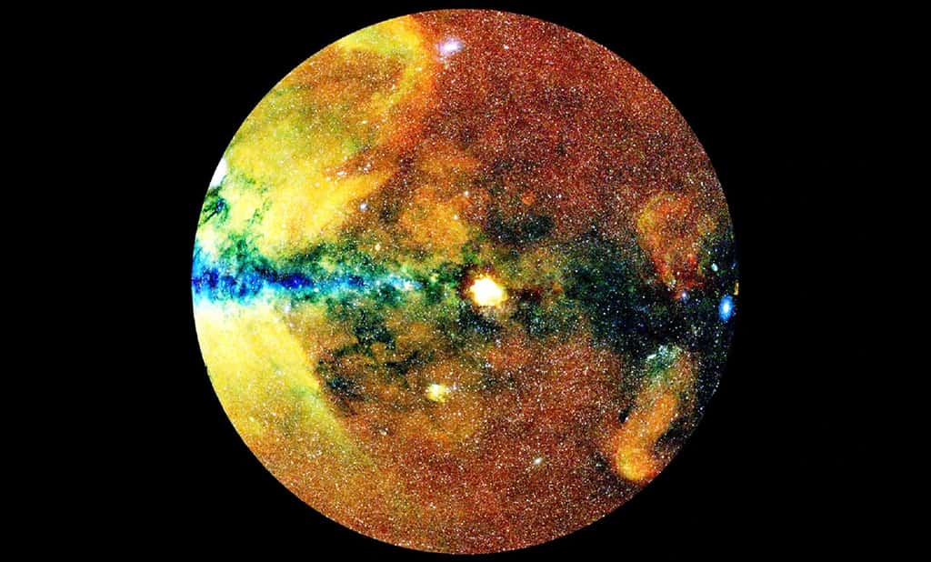Sur cette carte d'un hémisphère céleste, établie à partir des données du télescope eRosita, les couleurs reflètent les longueurs d'onde des rayons X. Les halos de gaz chauds entourant les amas de galaxies ont des émissions à large bande (blancs), tout comme les trous noirs (points blancs) ; les émissions diffuses ont de grandes longueurs d'onde (rouge) ; et dans les régions centrales de la Voie lactée, la poussière bloque les émissions de longueurs d'onde plus longues, de sorte que seuls les rayons X de longueur d'onde courte sont visibles (bleus ou noirs). Les nuages multicolores sont des restes de supernova. © MPE, J. Sanders pour le consortium eRosita