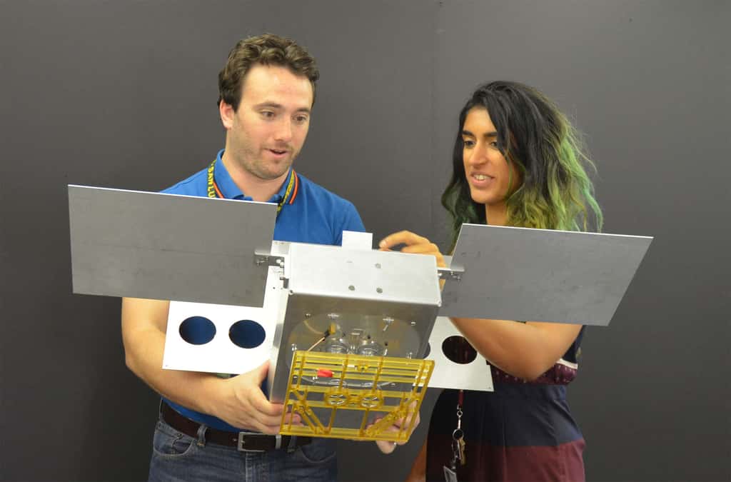  Deux des ingénieurs du projet MarCO, Joel Steinkraus et Farah Alibay, tenant dans leurs mains une maquette à l'échelle 1 d'un des deux CubeSat de MarCO. © JPL, Nasa