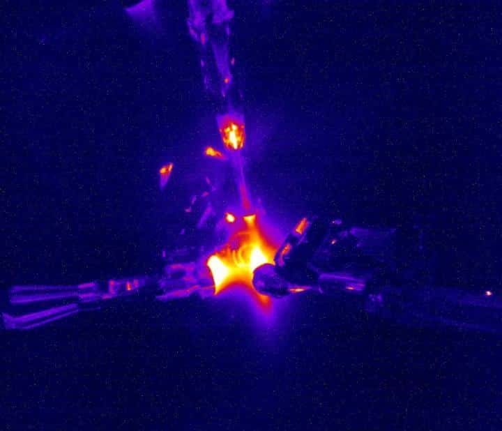 Une image de l'expérience avec fusion de noyaux d'hélium 3 à rapprocher de celles dans la vidéo de l'article ci-dessous. Les conditions très chaudes et très denses du cœur du Soleil sont créées par la compression d’une petite capsule en plastique remplie de gaz à une pression 10 fois supérieure à la pression atmosphérique à l'aide 192 faisceaux laser puissants. Certains des faisceaux laser focalisés apparaissent en haut et à gauche de l'image.© Don Jedlovec, LLNL