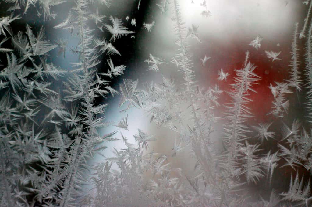  Exemple de cristallisation lorsque la vapeur d’eau, présente naturellement dans l’atmosphère, se transforme en glace au contact d’une vitre très froide en hiver, formant du givre. © Pascal Huot, Adobe Stock